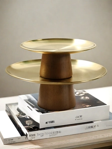 Detail of a two-tier golden metal and wood dessert stand for elegant table display
