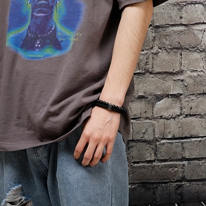 Men's double-layered black beaded bracelet with braided cord on wrist