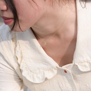 Minimalist gold S925 silver lightning bolt pendant necklace worn on a woman's collarbone