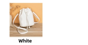Close-up of white PU leather bucket bag with drawstring closure on a wooden table