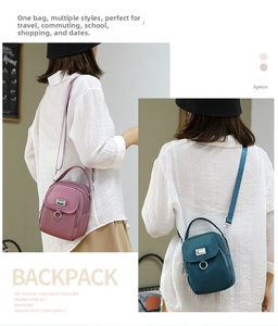 Detail view of multi-compartment oxford crossbody bags in pink-purple and dark green colors
