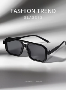 Detail view of stylish square double-bridge black sunglasses with grey lenses and thick frame