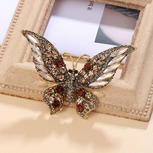 Élégante broche papillon en alliage doré avec strass ambrés et détails en cristal