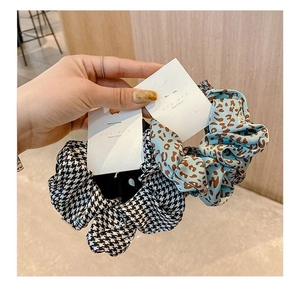 Close-up of hair scrunchies in houndstooth and leopard patterns with retail tags