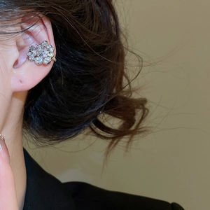 Gros plan détaillé d'un ear cuff fleuri en zircon sur une oreille de femme sans perçage
