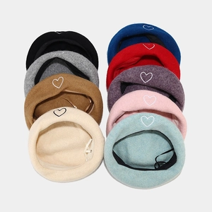 Flat lay of wool beret hats with heart embroidery showing nine various color options