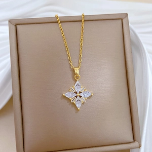 Detailed macro view of a gold clover necklace with four large crystal triangle stones