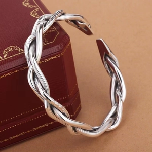 Macro shot of silver twisted braid texture on a minimalist open cuff bracelet