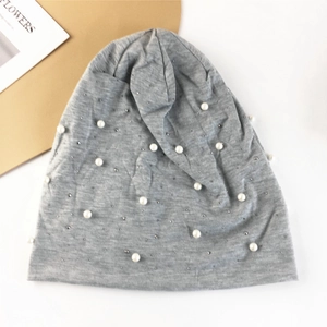 Détail du bonnet en maille grise avec perles blanches élégantes et strass brillants