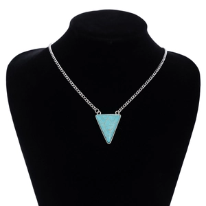 Detail of bohemian silver necklace with triangle turquoise pendant on a black bust