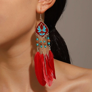 Detail of bohemian red feather earrings with blue beads and vintage gold hollow pattern