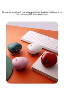Detailed view of portable electric head massagers in four colors on a desk setup