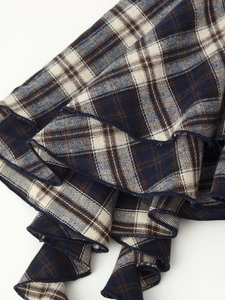 Detail shot of multi-layer ruffled hem in blue and white plaid fabric texture