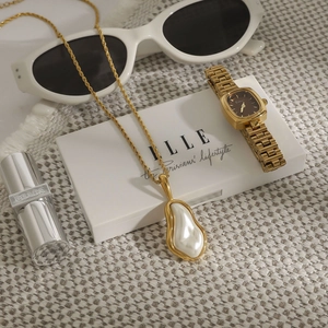 Close-up of gold twist chain necklace with irregular baroque pearl pendant