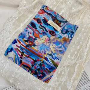 Detailed close-up of textured chenille pocket with artistic abstract print and brand tag