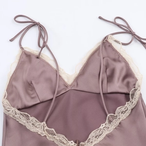 Detail showing delicate lace trim and adjustable tie-up silk straps on a dusty pink midi dress