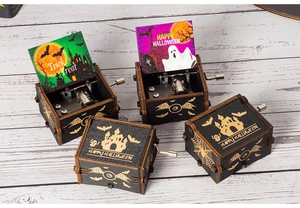 Detail of hand-cranked wooden Halloween music box featuring colorful Trick or Treat prints