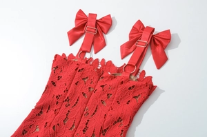 Detail showing red lace bodice with satin bow straps and delicate metal ring connectors