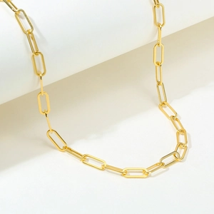 Macro view of gold stainless steel paperclip necklace with polished rectangular link