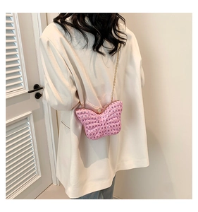Détail du sac papillon rose avec strass brillants et bandoulière en chaîne dorée