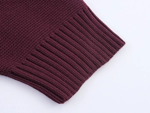 Macro shot of ribbed cuffs and waffle knit texture on a burgundy crewneck sweater