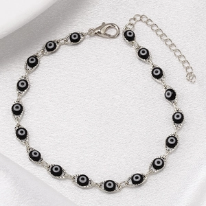 Close-up of silver chain bracelet with black evil eye beads and adjustable lobster clasp
