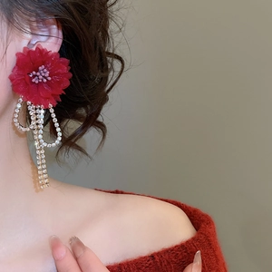 Detailed view of red fabric flower earrings with sparkling rhinestone long tassel chains