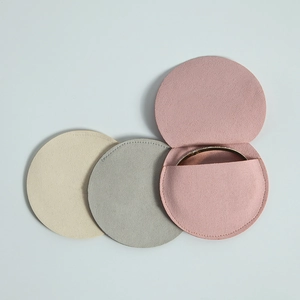 Three-color round microfiber jewelry pouches in pink and grey showing a gold bracelet