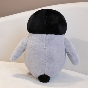 Close-up of soft grey plush penguin toy showing detailed round back and small black tail