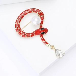 Detail of red enamel snake brooch with white pearl and teardrop rhinestone pendant