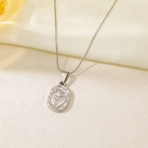 Detailed view of silver rose embossed oval pendant on a fine titanium steel chain necklace