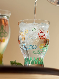 Macro shot of pouring water into a high borosilicate glass with colorful cartoon patterns