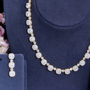 Close-up of zircon necklace and earrings set on blue velvet display stand
