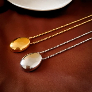 Minimalist geometric oval long sweater necklace in polished gold and silver metal finishes