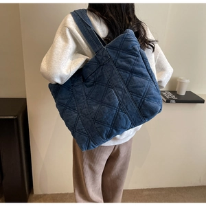 Vue détaillée du sac cabas en denim bleu foncé avec motif matelassé classique