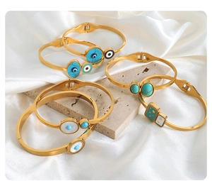 Detail of gold-plated stainless steel evil eye bracelets with colorful enamel inlay