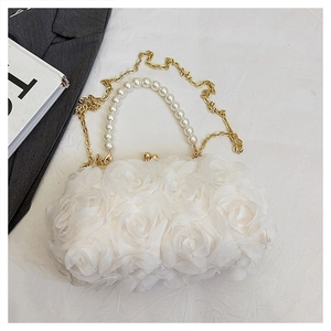 Détail de texture rosette 3D blanche sur sac de soirée avec anse perle et chaîne dorée
