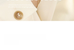 Detail of a double-layered gold blade chain bracelet worn with a cream blazer