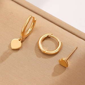 Close-up of gold-plated earring set featuring heart charms and zircon-studded hoops