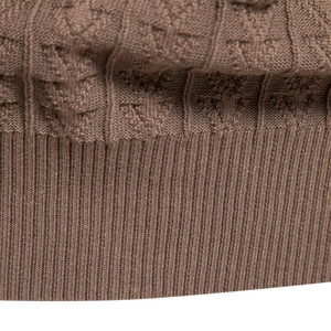 Close-up of brown knit sweater showing textured jacquard weave and ribbed cuff detail