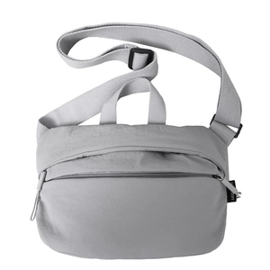 Detail of light gray nylon crescent bag with textured fabric and adjustable strap