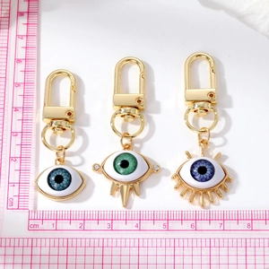 Detailed view of evil eye resin keychains in blue and green with gold alloy lobster clasps