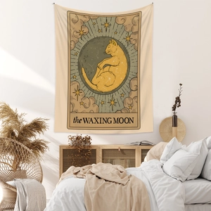 Detail of bohemian tarot cat tapestry with waxing moon design on minimalist bedroom wall