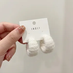 Elegant white faux fur hoop earrings with S925 silver needles on brand card display