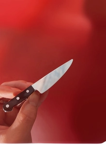 Close-up of a mini realistic dagger hair clip with silver blade and black riveted handle