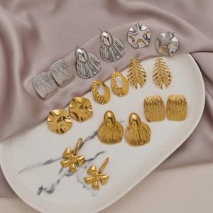 Minimalist stainless steel bow and geometric earring sets displayed on a ceramic tray