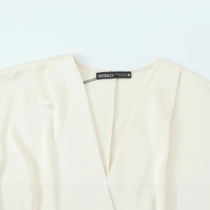 Front view of cream v-neck satin blouse for women featuring smooth silky fabric texture