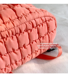 Dettaglio del tessuto trapuntato rosa corallo con trama a quadretti per zaino leggero