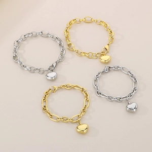 Dettaglio macro di bracciali a catena con ciondoli a cuore cavo in oro e argento