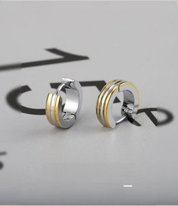 Detail von zweifarbigen Edelstahl-Creolen in Gold und Silber mit strukturierter Optik